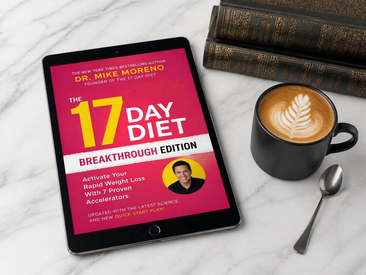 The 17 Day Diet Breakthrough Edition eBook displayed on a tablet next to a coffee cup and vintage books